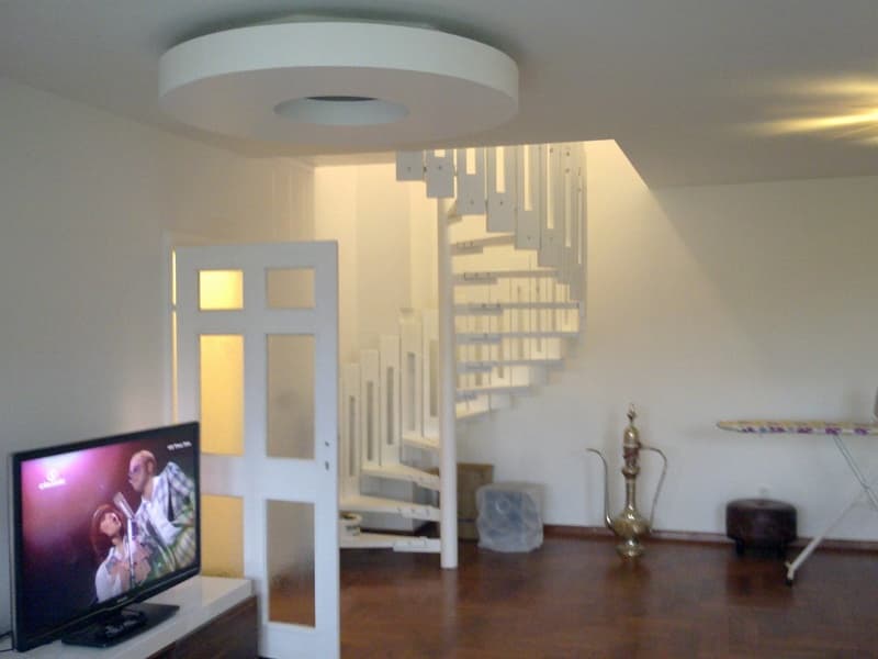 Bojanje dnevnog boravka s bijelim zidovima i spiralnim stubištem - soboslikarski radovi